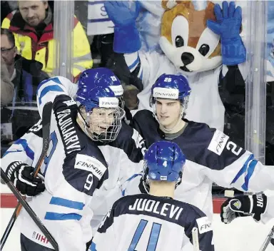  ?? Markku Ulander / Lehtikuva via The Associated Pres ?? Finland’s Jesse Puljujarvi, left, and Patrik Laine, second from left, are first and third in
scoring at the world junior tournament. Linemate Sebastian Aho is second.