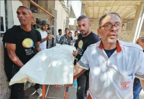  ?? MOHAMMED SALEM / REUTERS ?? People carry the body of one of the slain foreign workers from the World Central Kitchen in Rafah on Wednesday before transporti­ng them to their families outside Gaza.