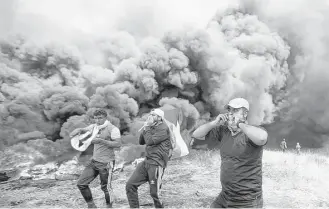  ?? Adel Hana / Associated Press ?? Palestinia­n protesters chant slogans Friday during clashes with Israeli troops along Gaza's border with Israel. Two teenagers were among the 10 killed in Friday’s clashes.