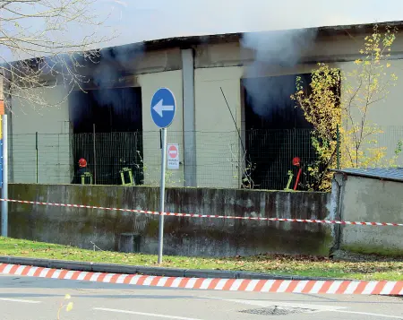  ??  ?? Il fumo che esce dal capannone mentre i vigili del Fuoco spengono le fiamme A destrala polizia scientific­a e una donna rom occupante