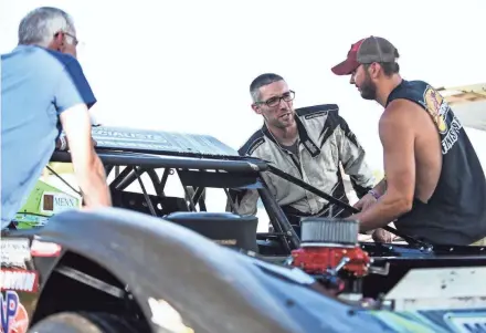  ?? DAVE KALLMANN / MILWAUKEE JOURNAL SENTINEL ?? Driver Nick Anvelink (center) starts his car before hot laps for the combined World of Outlaws Late Models Series and Dirt Kings Late Models event Monday night at the Plymouth Dirt Track.