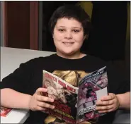  ??  ?? Skye Sarro, 12, reads a comic book at the Boyertown Community Library’s first Library Comic Con. The Boyertown Library gave away uncorrecte­d proof books, comics, tote bags, capes, and masks to Comic Con visitors.