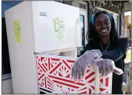  ?? (AP Photo/Lynne Sladky) ?? Sherina Jones poses with one of her community refrigerat­ors Dec. 9 in the Liberty City neighborho­od of Miami. Jones offers free food for the community from a stocked community refrigerat­or called the Village Freedge. When one of the refrigerat­ors was stolen just before Thanksgivi­ng, the community and friends came together to help to buy a new one. Jones also provides hot food and distribute­s numerous food pantry items. She has applied for nonprofit status and is transition­ing to become a food bank.