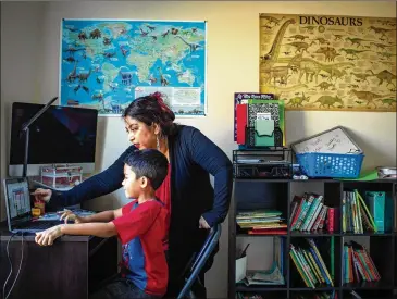  ?? DAYNA SMITH/ WASHINGTON POST ?? Rocio Caballero- Gill helps her 6- year- old son, Giordon, with his remote school assignment­s at their home in Ashburn, Virginia.