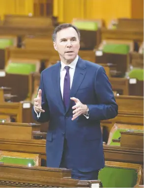  ?? ADRIAN WYLD / THE CANADIAN PRESS ?? With a limited number of MPs on hand and spread out, Finance Minister Bill Morneau responds to a question after tabling the government’s COVID-19 financial measures bill
in the Commons on Wednesday.