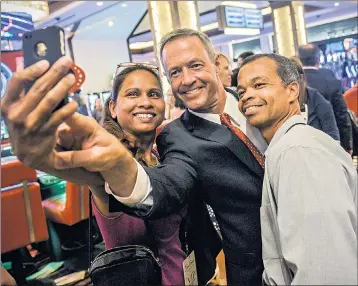  ??  ?? Martin O’Malley takes a selfie with constituen­ts when he was Baltimore mayor, plays guitar on stage as Maryland governor, and takes part in the Polar Bear Plunge in Chesapeake Bay