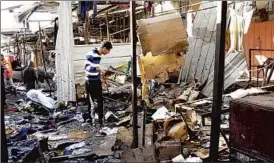  ?? AHMED MALIK/REUTERS PHOTO ?? Two bombs exploded Wednesday at a marketplac­e in Baghdad’s Dora district, killing 11. Soon after, bombs struck Christians nearby as they emerged from Christmas Mass.