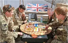  ??  ?? Throw of the dice: Prince Harry joins in playing Uckers in Afghanista­n in 2012