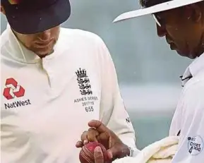  ??  ?? England captain Joe Root (left) and umpire Kumar Dharmasena inspecting the ball yesterday.