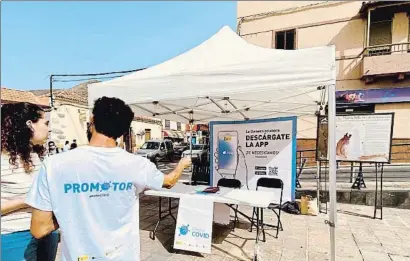  ?? ALEJANDRO NODA / REUTERS ?? Un voluntario y una residente en La Gomera, ante un panel informativ­o de la prueba piloto de Radarcovid