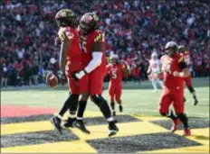  ?? NICK WASS — THE ASSOCIATED PRESS FILE ?? Maryland running back Javon Leake, left, celebrates his touchdown with offensive linemen Derwin Gray, center, and Spencer Anderson last week against Ohio State.