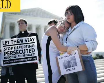  ?? WIN MCNAMEE/GETTY IMAGES ?? Nicole, right, and Michelle Edralin, whose father Cloyd Edralin was apprehende­d by federal agents, console each other outside the U.S. Supreme Court as the court upheld the ban imposing limits on travel from several Muslim nations.