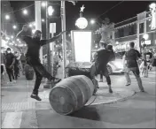  ?? ASSOCIATED PRESS ?? PROTESTERS OVERTURN TRASH cans as police try to clear a violent crowd Saturday in University City, Mo. Earlier, protesters marched peacefully in response to a not guilty verdict in the trial of former St. Louis police officer Jason Stockley.