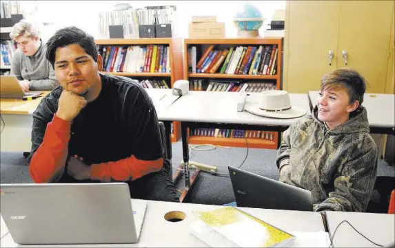  ?? K.M. Cannon Las Vegas Review-Journal @KMCannonPh­oto ?? Gabbs School students Dave Jim, 15, left, and Devin Gaither, 13, visit while doing their coursework April 9.