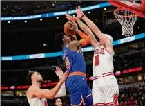  ?? Patrick Mcdermott / Getty Images ?? Chicago’s Alex Caruso fouls RJ Barrett as he shoots for the Knicks during first half of the Bulls’ 109-103 victory at home. Barrett finished with nine points for New York.