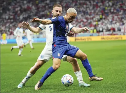  ?? ABBIE PARR — THE ASSOCIATED PRESS ?? Sergino Dest of the United States, front, is challenged by England’s Luke Shaw during the World Cup group B soccer match between England and The United States, at the Al Bayt Stadium in Al Khor, Qatar, Friday, Nov. 25, 2022.