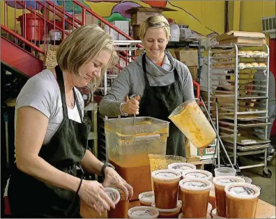  ?? RYON HORNE / RHORNE@AJC.COM PHOTOS ?? Amanda Marmins (left) and Kelly Griffin, both of Atlanta, volunteer in the kitchen at the Westside location of Souper Jenny to prepare soup for The Zadie Project, which helps feed the hungry in metro Atlanta.