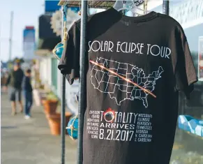  ?? (Mike Blake/Reuters) ?? ECLIPSE T-SHIRTS are shown for sale on Saturday in Depoe Bay, Oregon, a state that will be in today’s so-called path of totality.