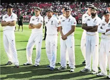  ??  ?? Dejected England captain Alastair Cook ( left) and teammates look on during the trophy presentati­on after Australia won the final Test in Sydney on Sunday.