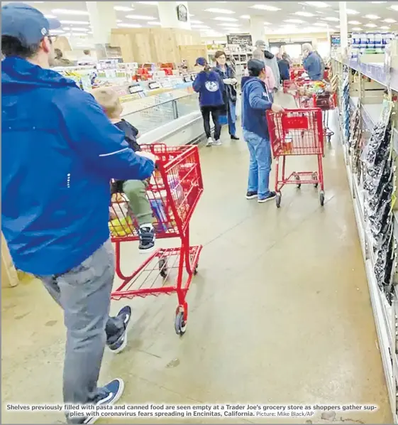  ?? Picture: Mike Black/AP ?? Shelves previously filled with pasta and canned food are seen empty at a Trader Joe’s grocery store as shoppers gather supplies with coronaviru­s fears spreading in Encinitas, California.