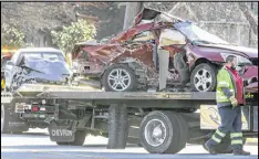  ?? JOHN SPINK / JSPINK@AJC.COM ?? A driver with Willard Wrecker Service prepares to move a car from the scene of a fatal crash on Lawrencevi­lle Highway on Thursday morning. The crash shut down the highway for two hours.