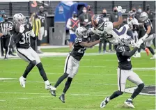  ?? Andy Cross, The Denver Post ?? Raiders strong safety Jeff Heath, left, catches a pass intended for Broncos wide receiver K. J. Hamler.