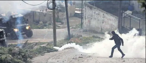  ?? REUTERS ?? A Palestinia­n protester runs away from tear gas fired by Israeli forces during clashes in Kobar, near Ramallah, in West Bank.