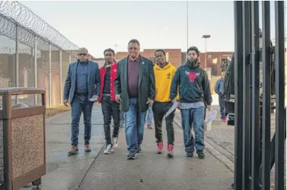 ?? SANTIAGO COVARRUBIA­S/FOR THE SUN-TIMES ?? Bishop Tavis Grant (left) and the Rev. Jesse Jackson (middle) walk out of Cook County Jail with Aaron Kinzer (second from left), Dionte Johnson and Brian Serratos, who had bail posted by Jackson on their behalf.