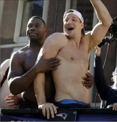  ?? Associated Press ?? Unusually mild temperatur­es allowed Patriots tight ends Dwayne Allen, left, and Woodland Hills’ Rob Gronkowski to go shirtless for the team’s victory parade through Boston.