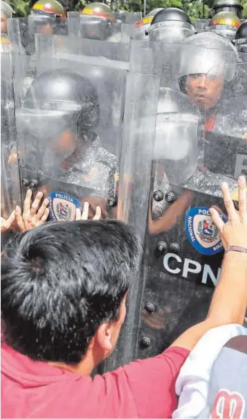  ?? EFE ?? Un grupo de jóvenes protestan ante la Policía Nacional Bolivarian­a