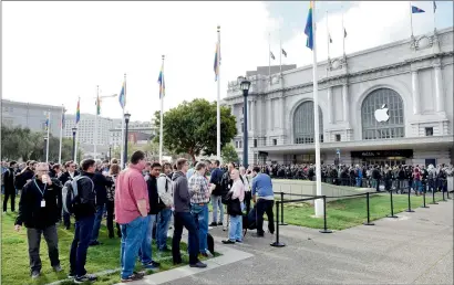  ?? — Bloomberg file ?? Attendees wait in line outside the Bill Graham Civic Auditorium ahead of the Apple WWDC in San Francisco.