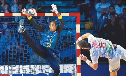  ??  ?? Goleiro e destaque do Brasil, Maik Santos tenta defender o arremesso do pivô norueguês Bjarte Myrhol