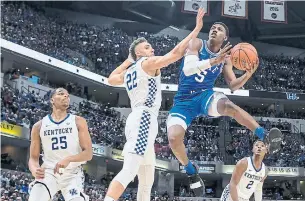  ?? AJ MAST PHOTOS THE ASSOCIATED PRESS ?? Duke’s R.J. Barrett shoots around Kentucky’s Reid Travis during action at the Champions Classic in Indianapol­is. The Blue Devils appear unstoppabl­e led by Barrett and Zion Williamson, left.