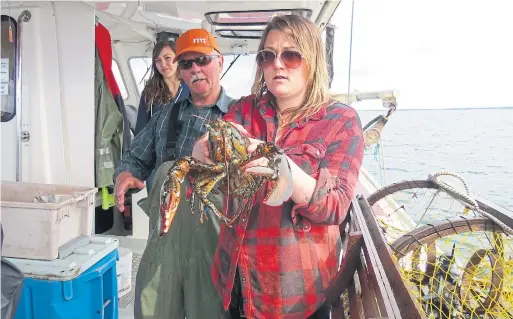  ?? PATRICK BRENNAN PHOTOS SPECIAL TO THE TORONTO STAR ?? Captain Joey Gautier introduces food writer Charlotte Langley to one of his fresh caught lobsters in the waters off Prince Edward Island.