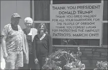  ?? ERIN MAUPIN VIA AP ?? From left, Lyle Hammond,susie Hammond and April Hammond pose for a photo Tuesday in their Burns, Ore., yard. A sign nearby thanks President Donald Trump for pardoning family members Dwight Hammond and Steven Hammond.