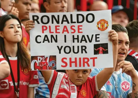  ?? Foto: dpa ?? Kein seltener Anblick auf der Tribüne: Manchester‐United‐Fans rissen sich regelrecht um ein Trikot von Cristiano Ronaldo nach dessen Wechsel.