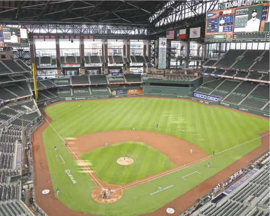  ??  ?? The Rangers’ Lance Lynn delivers the first pitch at empty Globe Life Field to David Dahl of the Rockies.