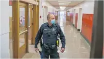  ?? ?? Bradley police Officer Roger Tambling, the school resource officer at BradleyBou­rbonnais Community High School, walks the hallways in January.