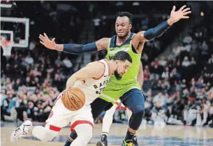  ?? ANDY CLAYTON-KING THE ASSOCIATED PRESS ?? Fred VanVleet, front, drives against Timberwolv­es’ Josh Okogie on Saturday in Minneapoli­s.