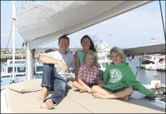  ??  ?? FILE PHOTO Brad and Karen Cook, and their two sons, Charlie and Ben, are seen aboard the Hangtime, a 47-foot catamaran. The family spent the summer sailing around the Maritime provinces, living full-time aboard their boat.