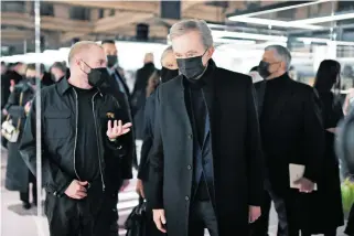  ?? /AFP ?? Presidente y director ejecutivo de LVMH y Bernard Arnault, con máscaras faciales, asisten al desfile de la colección Primavera-Verano 2021 de Fendi
