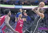  ?? MATT SLOCUM — THE ASSOCIATED PRESS ?? The Nets’ Kevin Durant, right, goes up for a shot against the 76ers’ Matisse Thybulle, center, and Joel Embiid during the first half on Friday in Philadelph­ia.