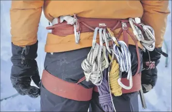  ?? Photos by Mark Johanson / Chicago Tribune ?? Larry Shiu, a teacher with Yamnuska Mountain Adventures, keeps extra ropes and carabiners on his harness.