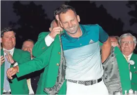 ?? DAVID GOLDMAN/AP ?? Danny Willett puts a green jacket on Sergio Garcia after Garcia won the Masters on Sunday in Augusta, Ga.