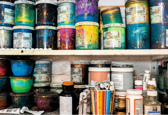  ??  ?? Splashed pots of vivid colour are stacked up on the shelves in Jemma’s Wiltshire studio, ready to transform her paper into dazzling patterns.