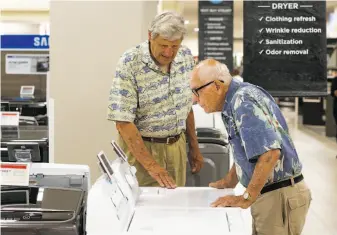  ?? Michael Macor / The Chronicle ?? Carl Bianchini (left) of San Carlos shops for a washer Tuesday with Aldo Dossola of Menlo Park at the Sears store at Tanforan in San Bruno. Sears has a new partnershi­p with Amazon.