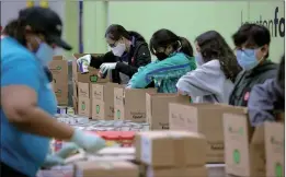  ?? Photo: AFP ?? Volunteers pack emergency distributi­on boxes that will be given out to residents in need after the winter storm Uri at the Houston Food Bank on Saturday in Houston, Texas.