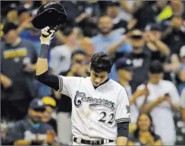  ?? Aaron Gash ?? The Associated Press Christian Yelich acknowledg­es an ovation at Miller Park after hitting a triple to cap his second cycle against the Reds in 20 days, keying the Brewers’ 8-0 win Monday.