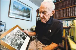  ?? KRISTOPHER SKINNER — STAFF ARCHIVES ?? Former Marine and WWII veteran Enrico Cinquini holds a photo of himself and a comrade taken at Cape Gloucester by Joe Rosenthal as he recalls stories from his service during WWII at his home in Oakley. Cinquini agrees that Rosenthal deserves to be honored.