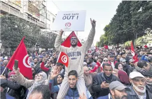  ?? AFP ?? Tunisian demonstrat­ors carry placards during a protest in central Tunis against President Kais Saied on Jan 14.